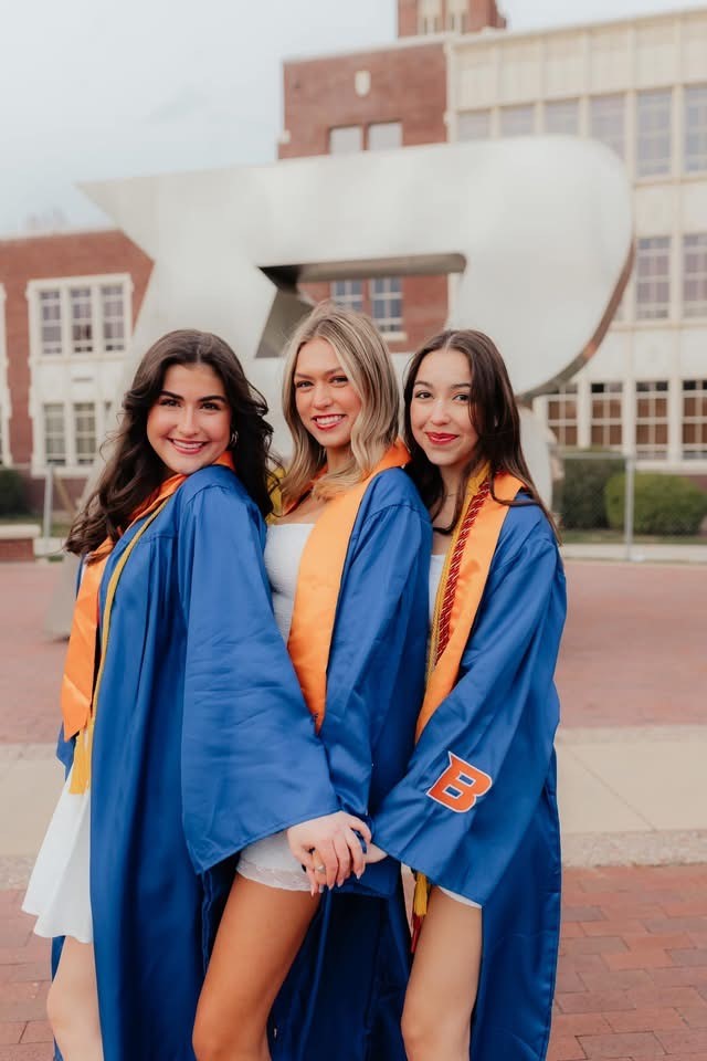 Lauren Vance and fellow graduates celebrating Boise State University commencement in blue gowns with orange stoles  