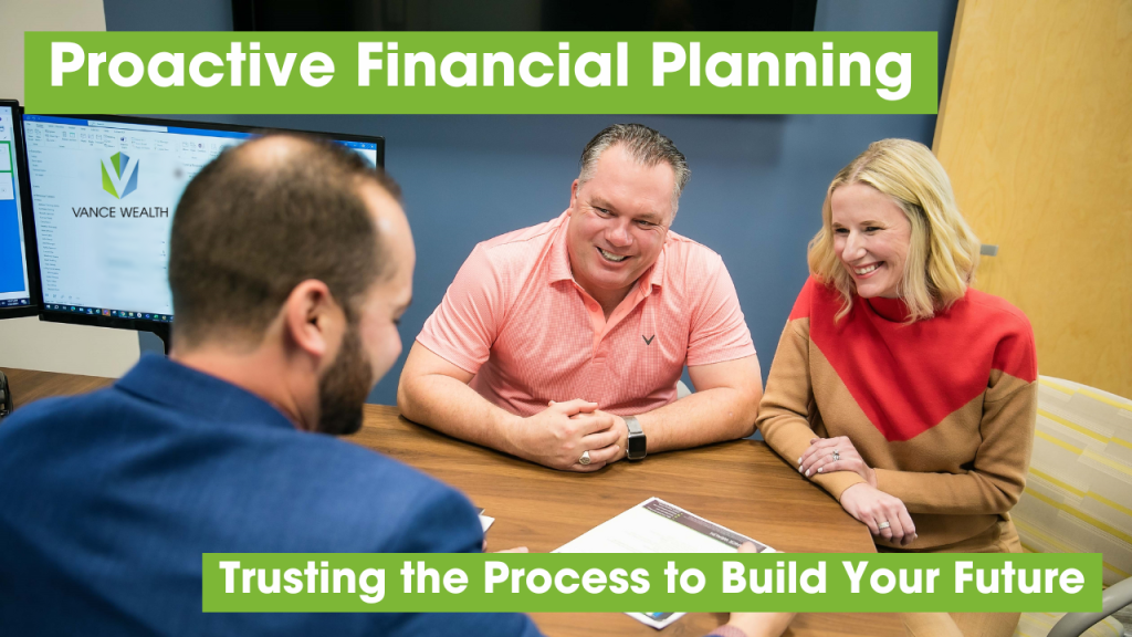 A financial advisor meets with a couple at a conference table, reviewing documents and discussing proactive financial planning in a bright office setting.
